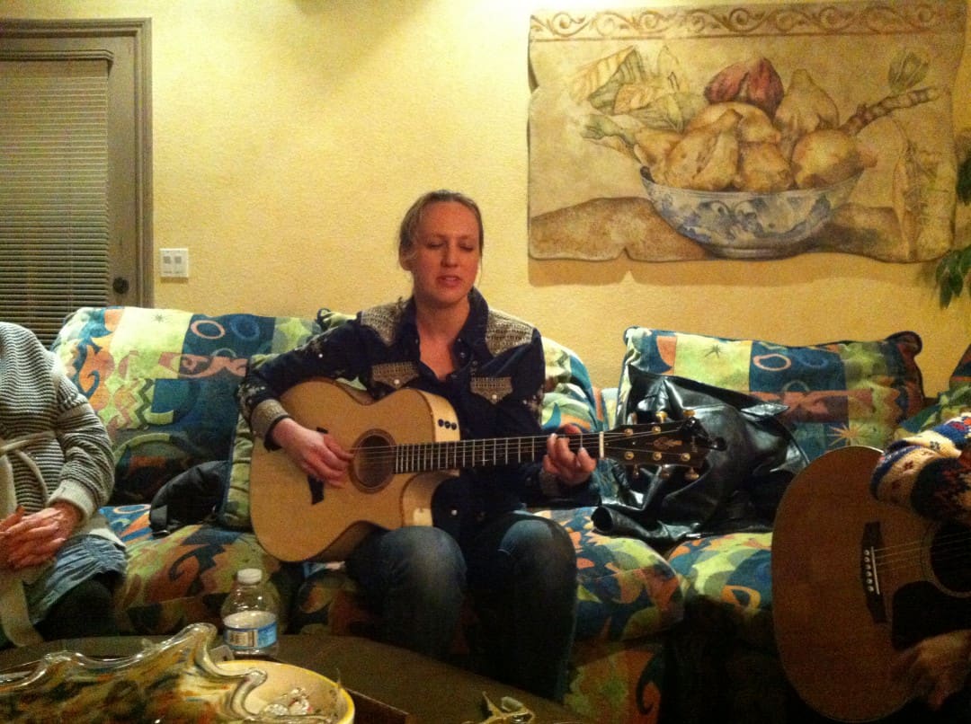 Ana Egge playing on the couch after the house concert.